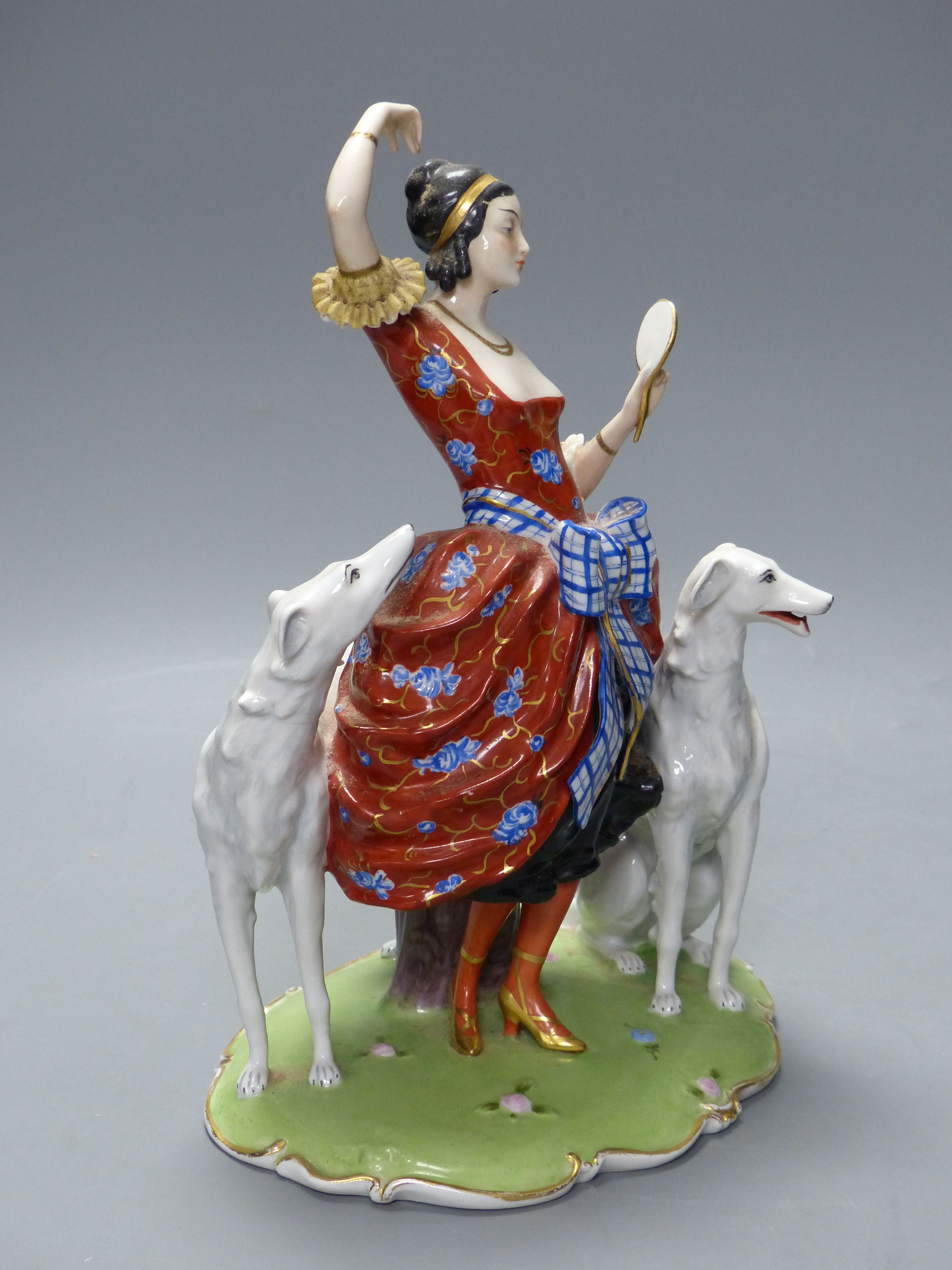 An Art Deco Fraureuth group modelled as a lady wearing a red gown flanked by two Borzoi dogs, H 28cm
